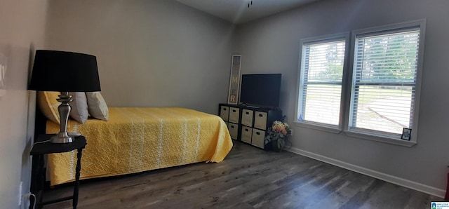 bedroom with baseboards and wood finished floors