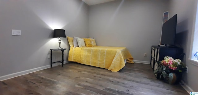 bedroom featuring baseboards and wood finished floors