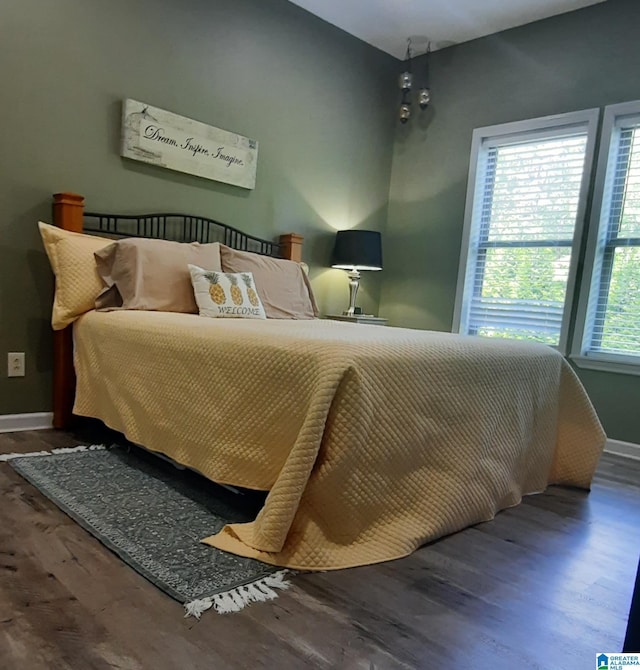 bedroom featuring baseboards and wood finished floors