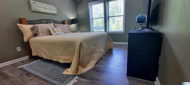 bedroom with baseboards and wood finished floors