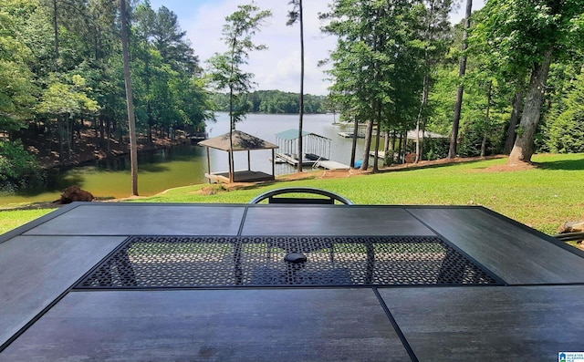 view of swimming pool with a lawn and a water view