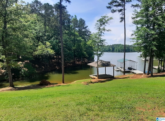 dock area with a lawn and a water view