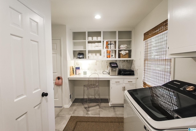 interior space with decorative backsplash, built in study area, light countertops, white cabinets, and recessed lighting