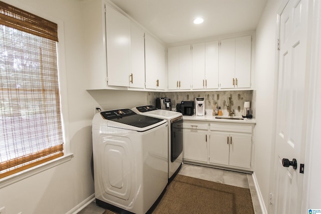 laundry area with baseboards, recessed lighting, separate washer and dryer, a sink, and cabinet space