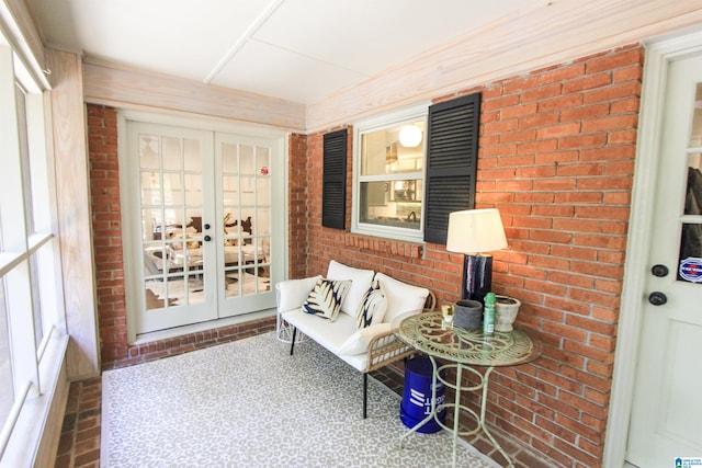 sitting room featuring french doors and brick wall