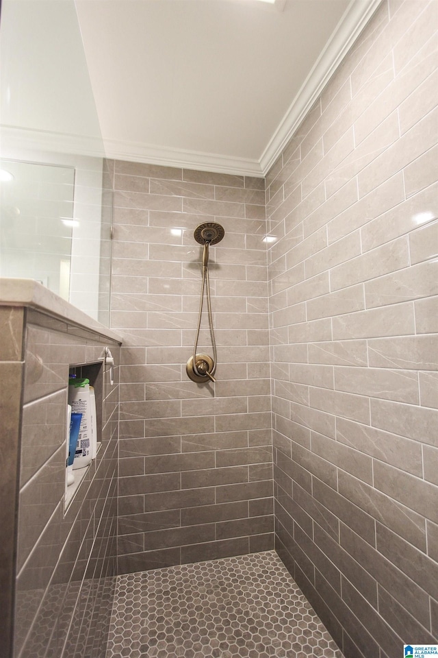 bathroom featuring crown molding and a tile shower