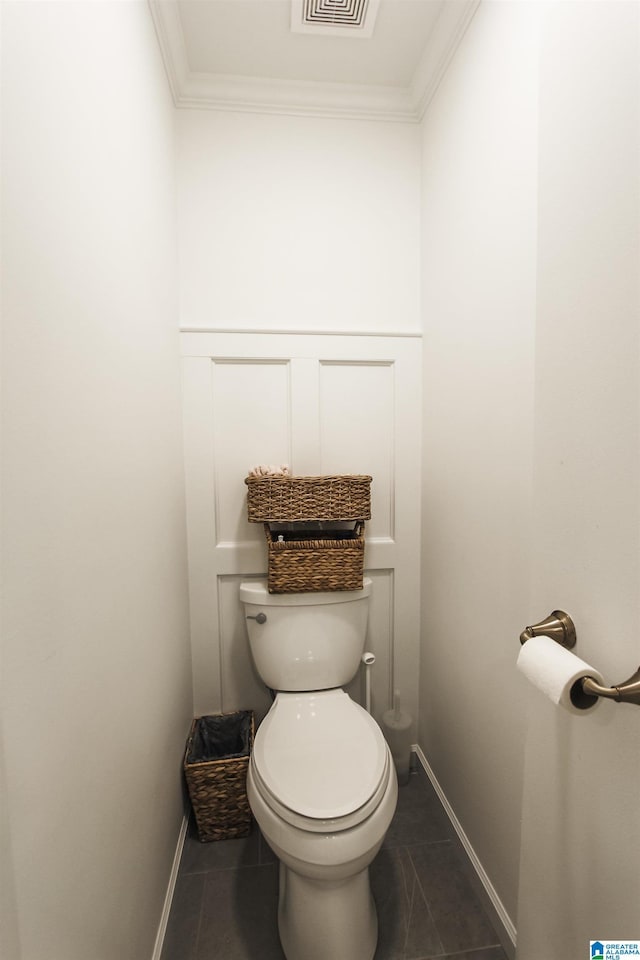 bathroom with crown molding, toilet, baseboards, and tile patterned flooring