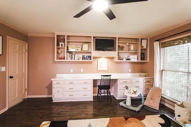 office area featuring ceiling fan, dark wood finished floors, built in desk, baseboards, and ornamental molding