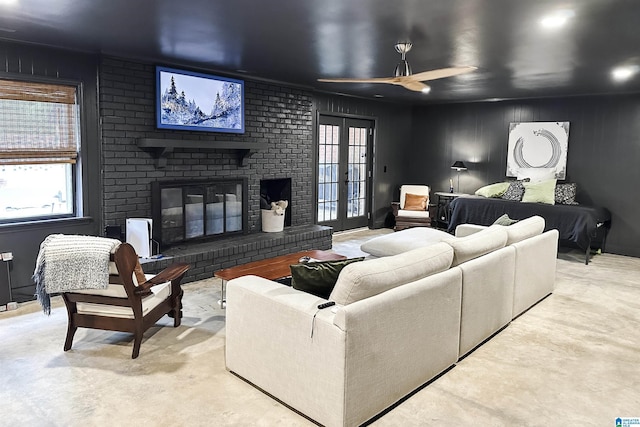 living area with a brick fireplace and ceiling fan