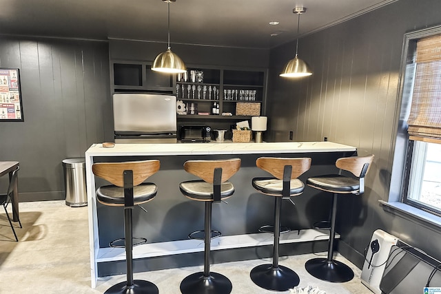 bar with decorative light fixtures, a toaster, wooden walls, and fridge