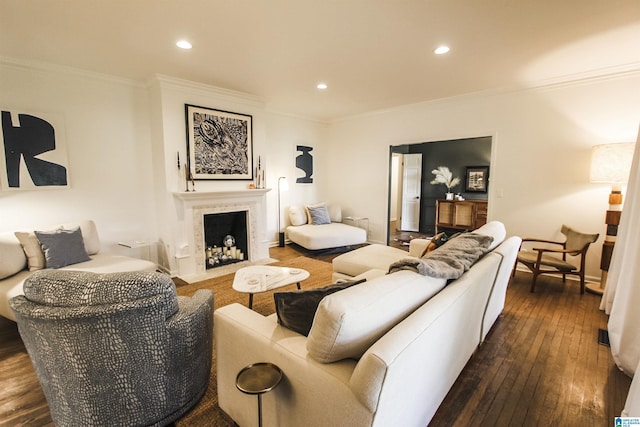 living room with recessed lighting, ornamental molding, dark wood finished floors, and a fireplace with flush hearth