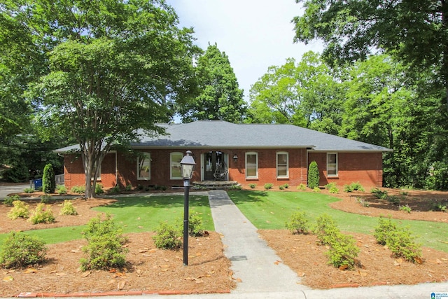 ranch-style home featuring brick siding and a front lawn