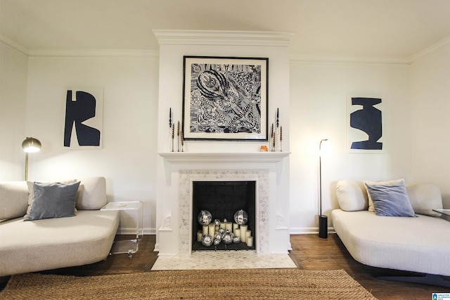 living room featuring crown molding, baseboards, a fireplace, and wood finished floors