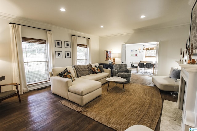 living room featuring an inviting chandelier, ornamental molding, recessed lighting, and wood finished floors
