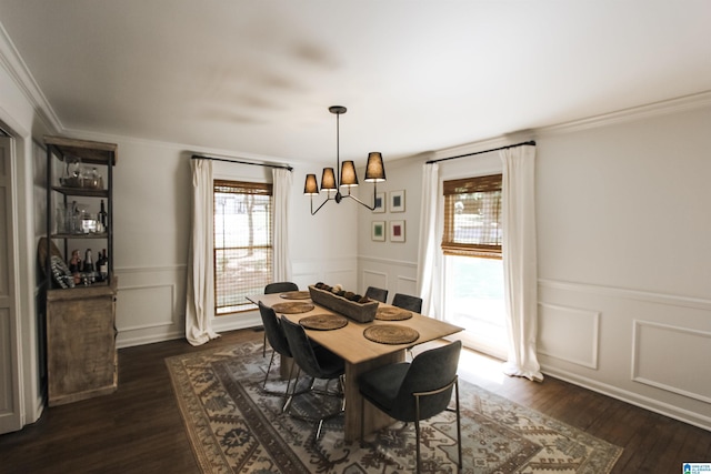 dining room featuring crown molding, a decorative wall, dark wood-type flooring, and a notable chandelier