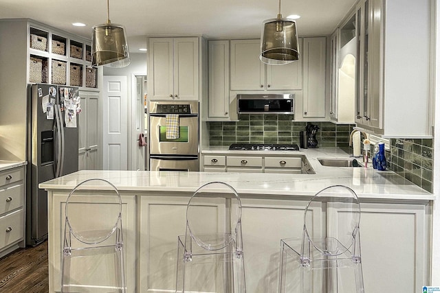 kitchen featuring a sink, appliances with stainless steel finishes, decorative backsplash, and light countertops