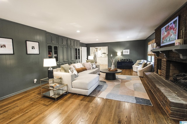 living area with recessed lighting, wood finished floors, and a fireplace