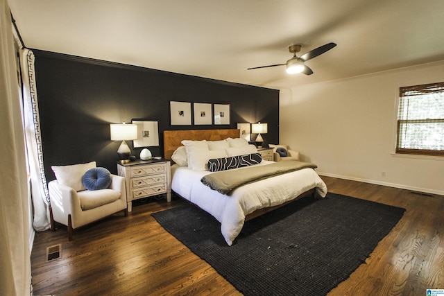 bedroom featuring visible vents, crown molding, dark wood-style flooring, baseboards, and a ceiling fan