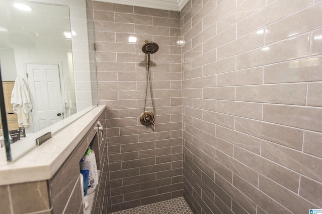full bath with crown molding and a tile shower
