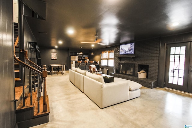 living area featuring finished concrete floors, recessed lighting, stairs, and a fireplace