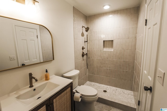 full bathroom with vanity, tile patterned floors, a tile shower, and toilet