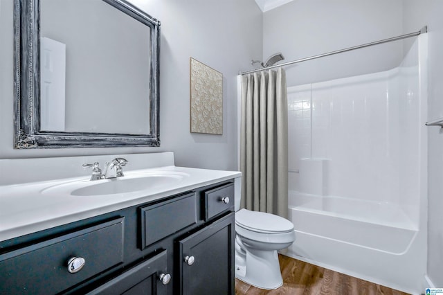 bathroom with vanity, wood finished floors, toilet, and shower / bath combo with shower curtain