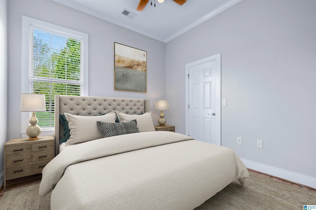 bedroom with a ceiling fan, baseboards, visible vents, and ornamental molding