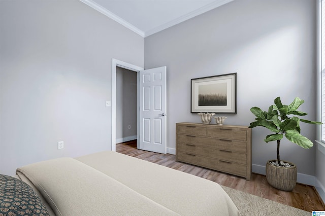 bedroom with crown molding, baseboards, and wood finished floors