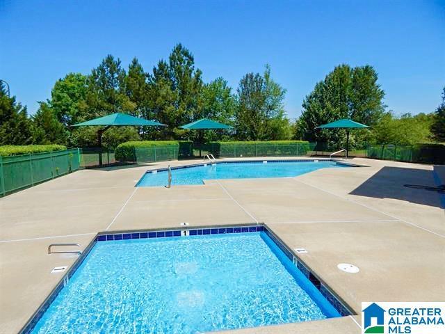 community pool featuring a patio and fence