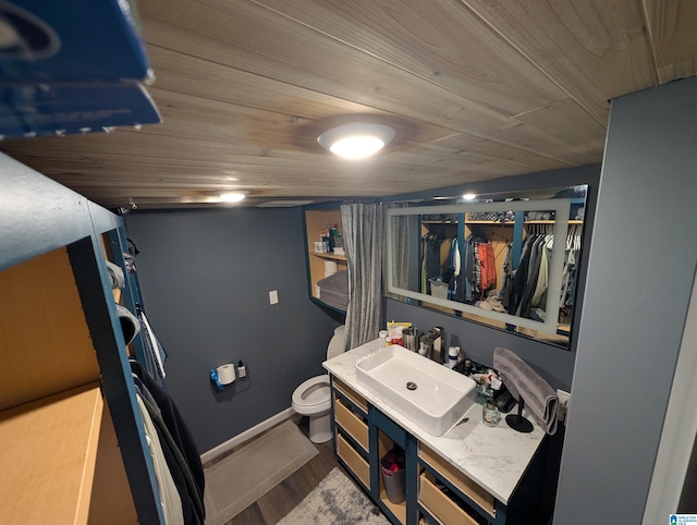 bathroom featuring wood ceiling, toilet, wood finished floors, and vanity
