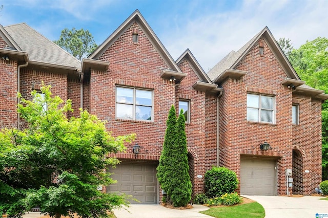 view of front of house featuring brick siding, driveway, and a garage