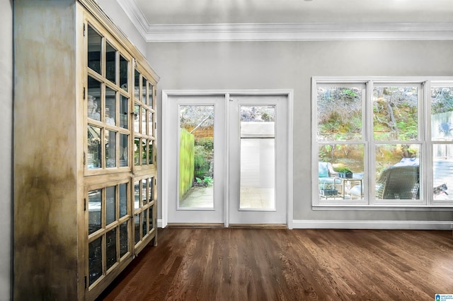 doorway with crown molding, baseboards, and dark wood-style flooring