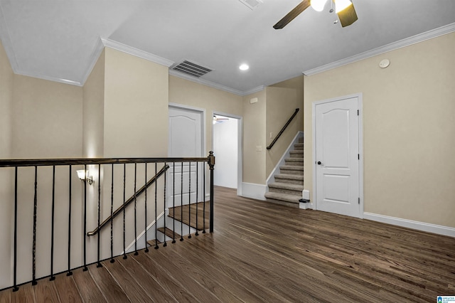 interior space featuring crown molding, visible vents, wood finished floors, baseboards, and ceiling fan