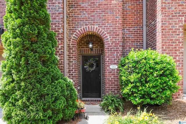 doorway to property featuring brick siding