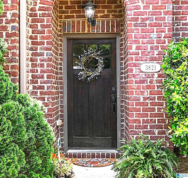 doorway to property with brick siding