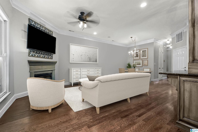 living area with a fireplace, ceiling fan with notable chandelier, baseboards, visible vents, and ornamental molding