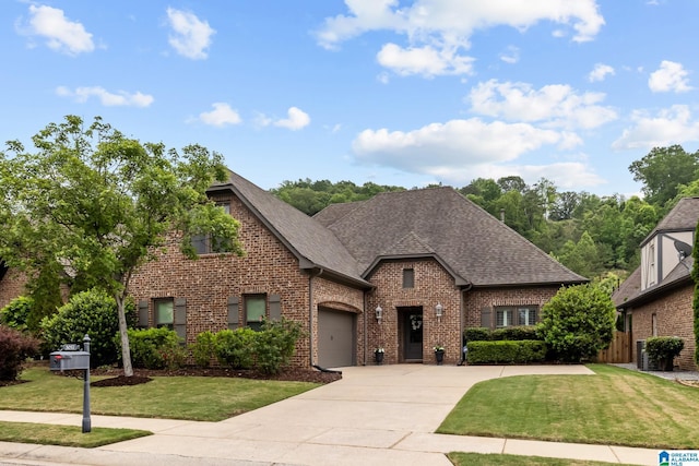 3057 Valley Ridge Rd, Hoover, AL 35242 - view of front of property featuring a front yard, brick siding, a shingled roof, an attached garage, and driveway