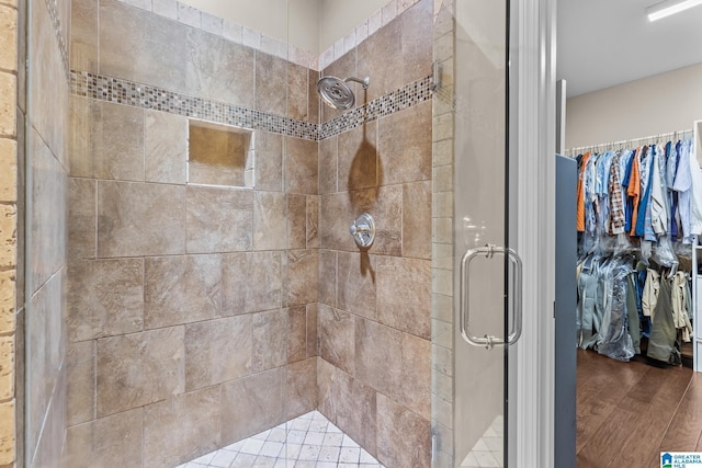 3057 Valley Ridge Rd, Hoover, AL 35242 - full bathroom featuring a walk in closet, a stall shower, and wood finished floors