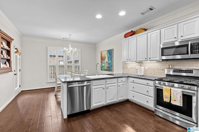 3057 Valley Ridge Rd, Hoover, AL 35242 - kitchen featuring white cabinets, a sink, a chandelier, stainless steel appliances, and a peninsula