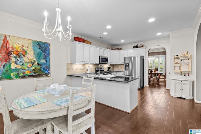 3057 Valley Ridge Rd, Hoover, AL 35242 - kitchen featuring appliances with stainless steel finishes, arched walkways, a peninsula, a notable chandelier, and ornamental molding