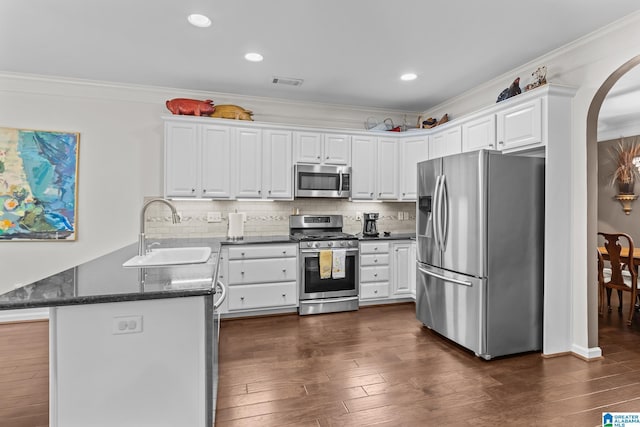 3057 Valley Ridge Rd, Hoover, AL 35242 - kitchen featuring arched walkways, a sink, a peninsula, stainless steel appliances, and white cabinetry