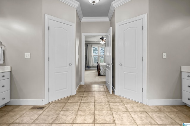 hall featuring baseboards, ornamental molding, and visible vents