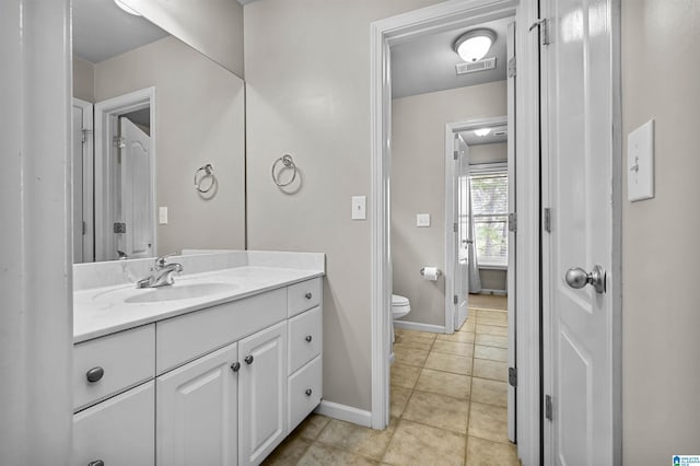 bathroom with visible vents, vanity, tile patterned floors, baseboards, and toilet