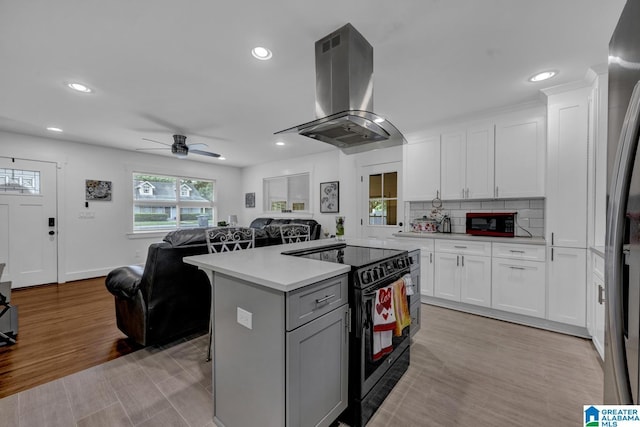 3824 Midway Rd, Adamsville, AL 35005 - kitchen with light countertops, white cabinets, island exhaust hood, and black appliances