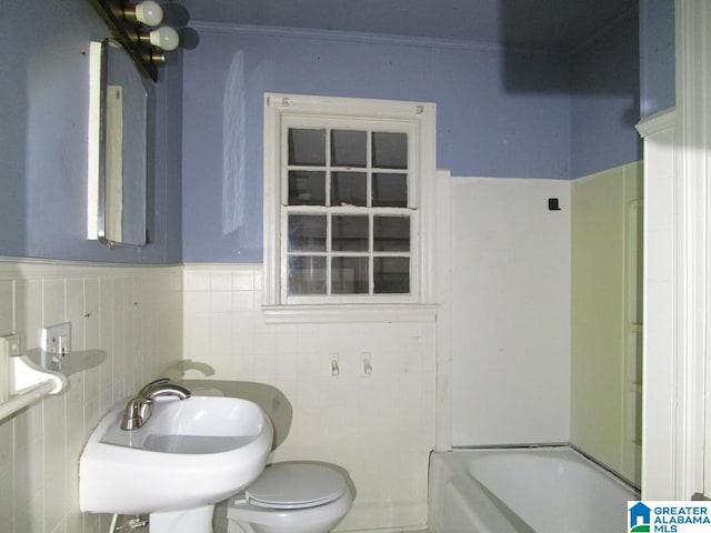 full bath featuring crown molding, toilet, tile walls, and a sink