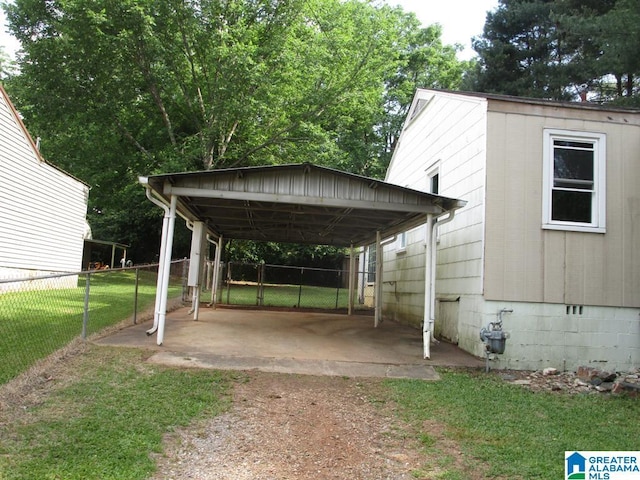 exterior space featuring fence, a carport, and driveway