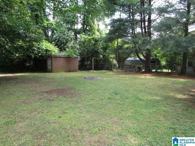 view of yard featuring fence, an outbuilding, and a shed