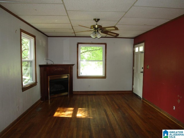 unfurnished living room featuring ceiling fan, a wealth of natural light, wood finished floors, and a fireplace