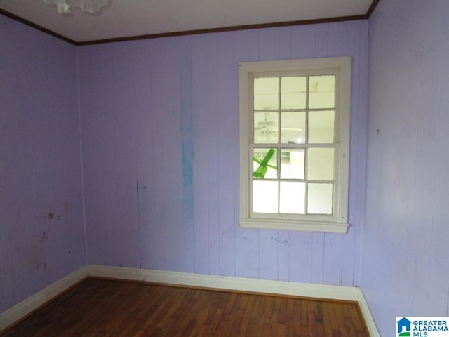 unfurnished room with baseboards, ornamental molding, and dark wood-type flooring