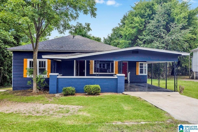 view of front of home with roof with shingles, an attached carport, driveway, and a front yard